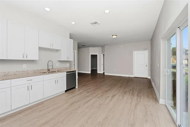 a kitchen with granite countertop a sink and cabinets