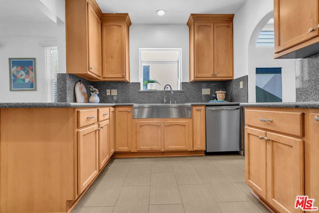 a kitchen with granite countertop a sink a stove oven and white cabinets