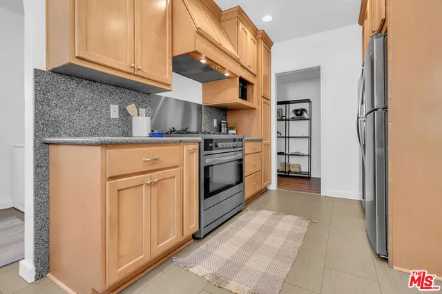 a kitchen with stainless steel appliances granite countertop a stove and a refrigerator