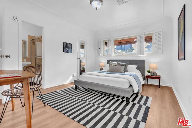 a bedroom with a bed and wooden floor