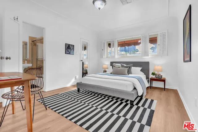 a bedroom with a bed and wooden floor