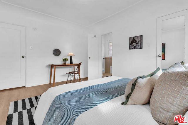 a bedroom with a bed and a lamp on dresser