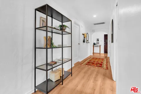 a view of hallway with a large window and a rug