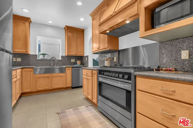 a kitchen with stainless steel appliances granite countertop a stove a sink and a microwave