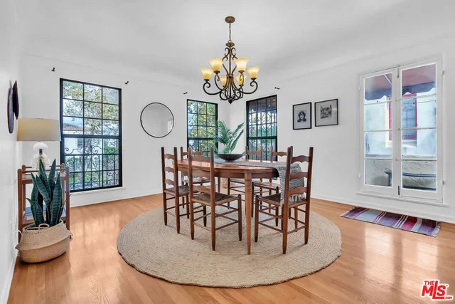 a view of a dining room with furniture a chandelier and wooden floor