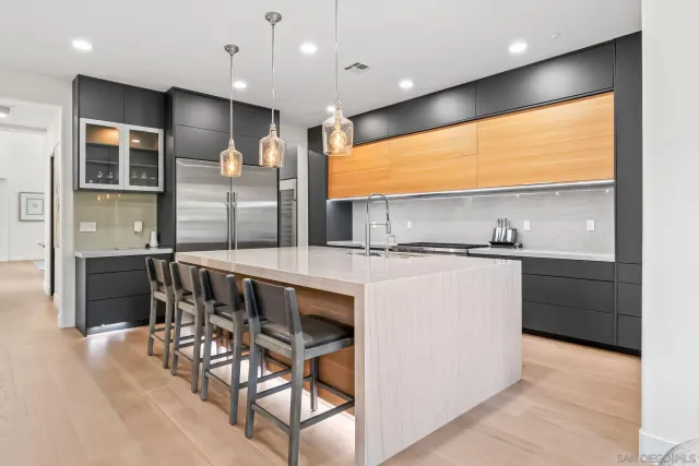 a kitchen with stainless steel appliances kitchen island granite countertop a table chairs sink and cabinets