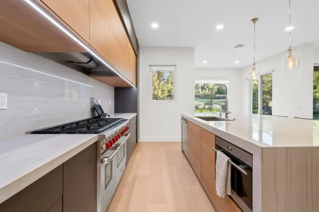 a large kitchen with stainless steel appliances granite countertop a large stove a sink and a refrigerator