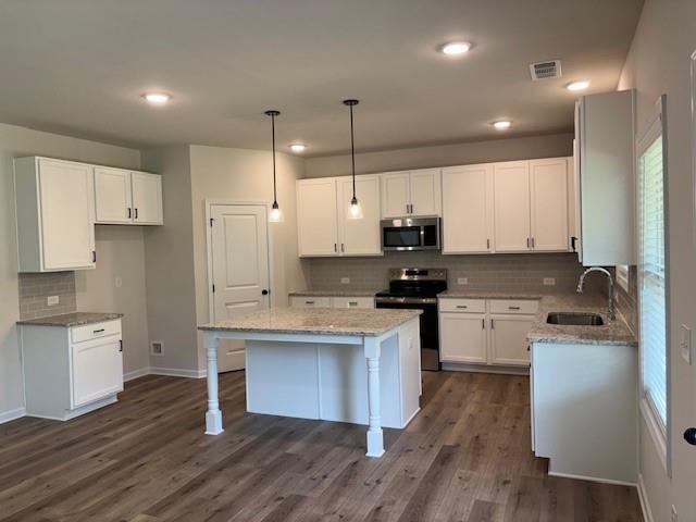 345 Rodeo Drive Auburn, GA 30011 - Photo 10 of 22 a kitchen with a sink a stove a refrigerator and white cabinets