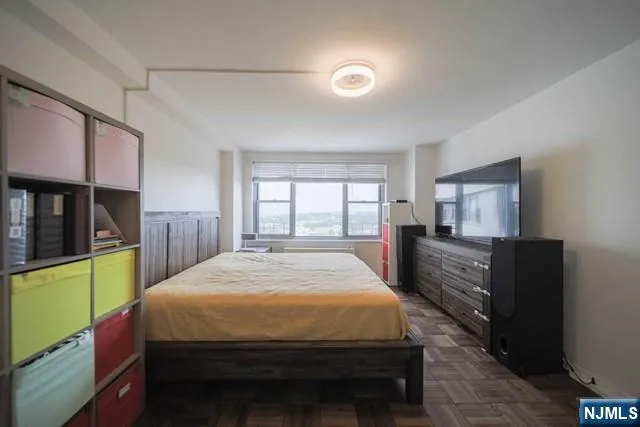 a bedroom with a bed and large windows