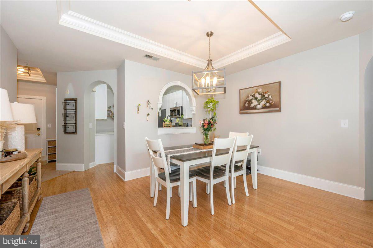 2500 Waterside Drive, Unit 110 Frederick, MD 21701 - Photo 22 of 106 a view of a dining room with furniture a chandelier and wooden floor