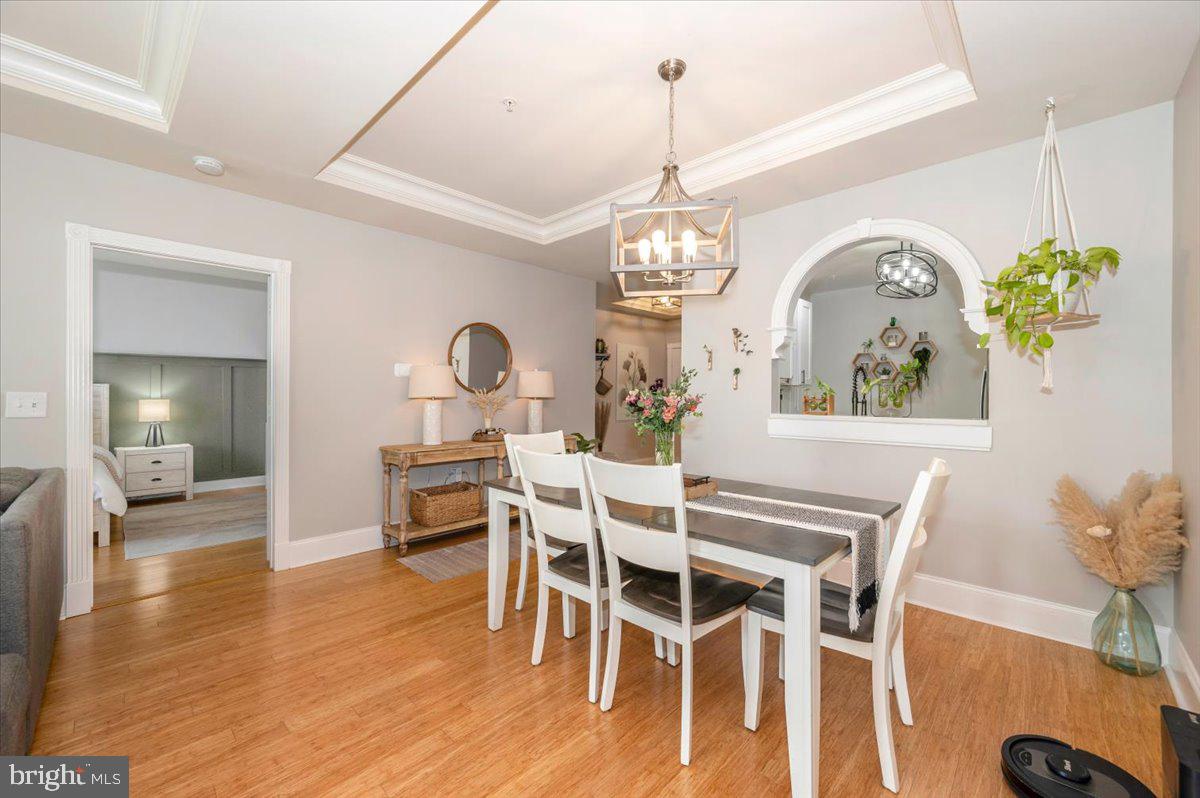 2500 Waterside Drive, Unit 110 Frederick, MD 21701 - Photo 24 of 106 a view of a dining room with furniture a chandelier and wooden floor