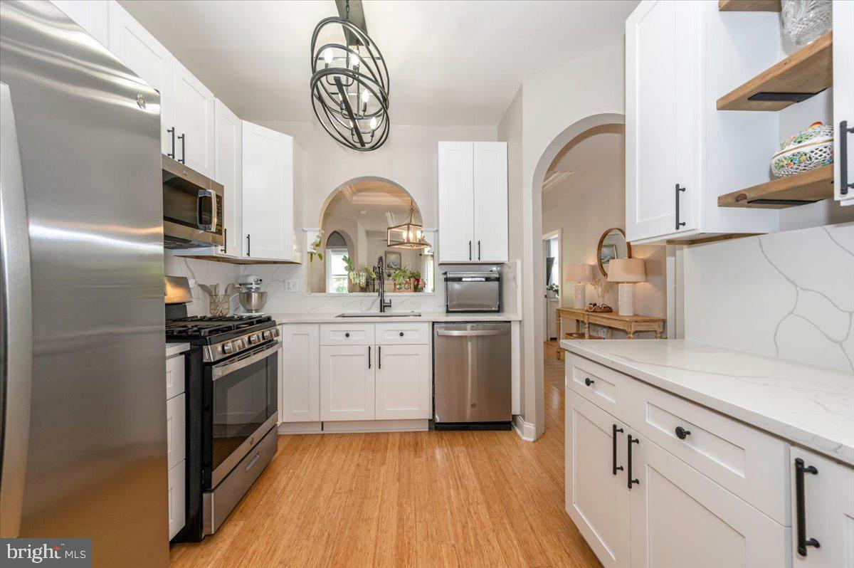 2500 Waterside Drive, Unit 110 Frederick, MD 21701 - Photo 28 of 106 a kitchen with stainless steel appliances granite countertop a sink a stove top oven with wooden floor