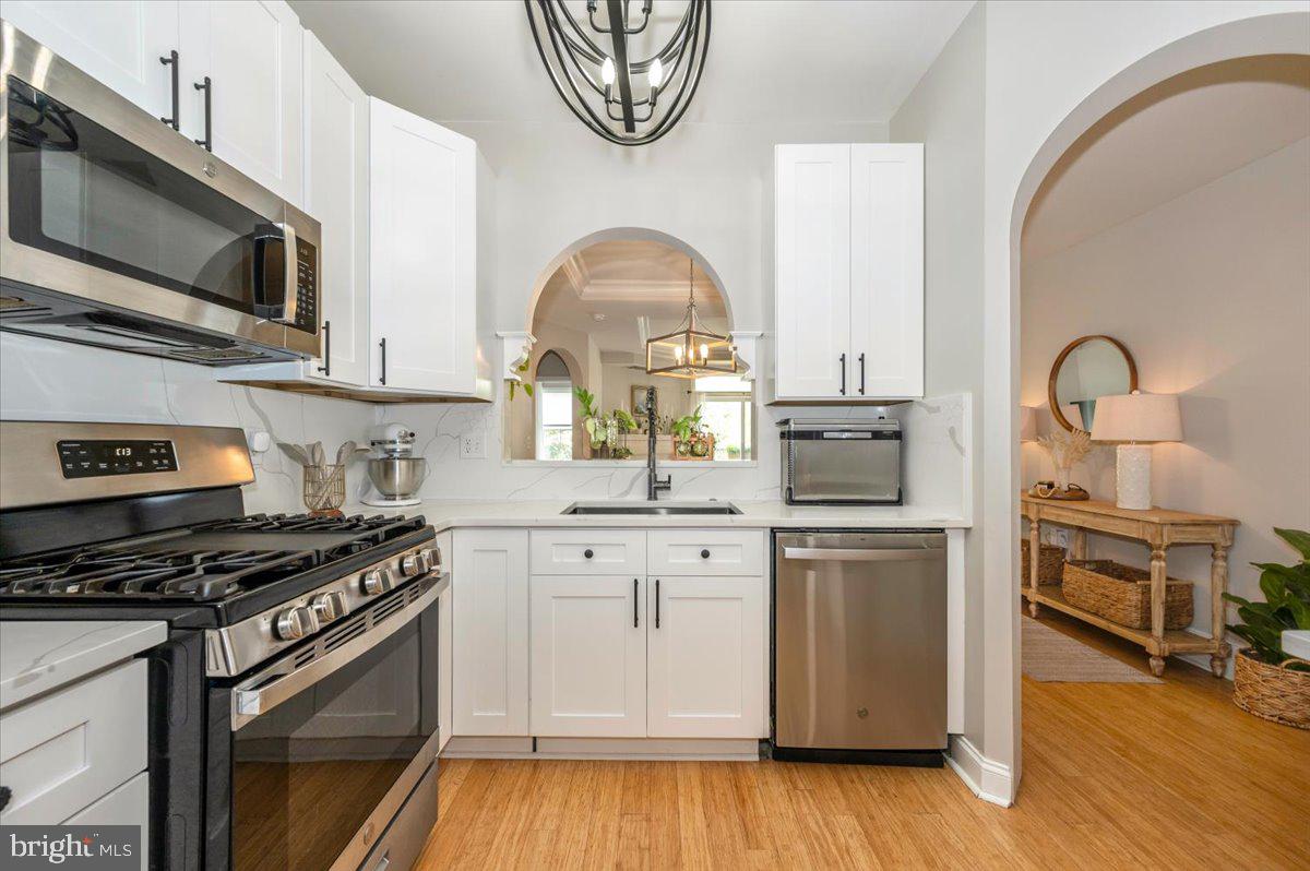 2500 Waterside Drive, Unit 110 Frederick, MD 21701 - Photo 31 of 106 a kitchen with stainless steel appliances a stove cabinets and a wooden floor