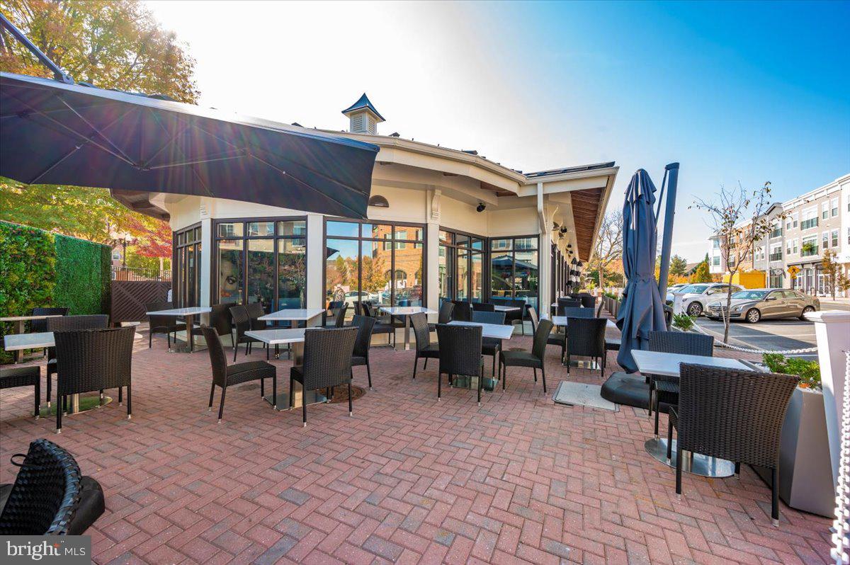 2500 Waterside Drive, Unit 110 Frederick, MD 21701 - Photo 100 of 106 a view of a patio with dining table and chairs under an umbrella