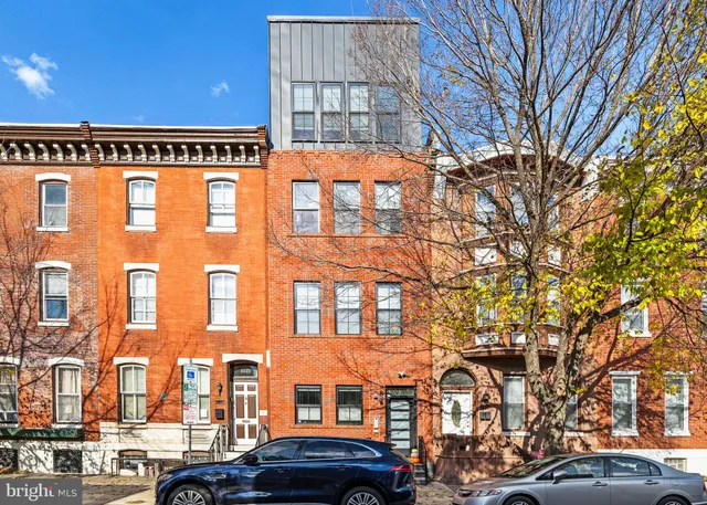 a front view of a building with a lot of cars parked