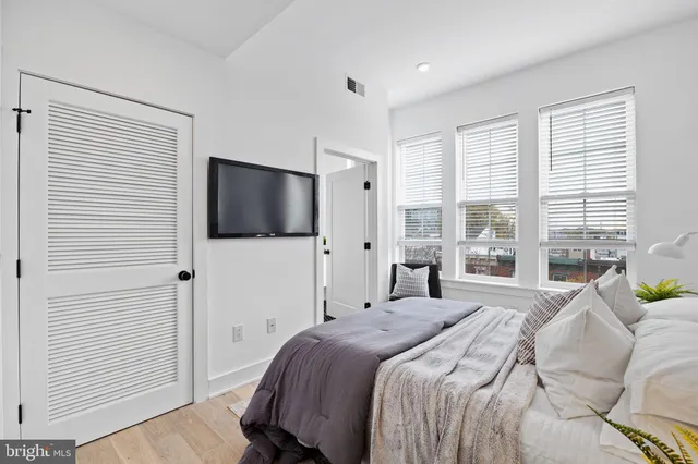 a bedroom with a bed tv and a window