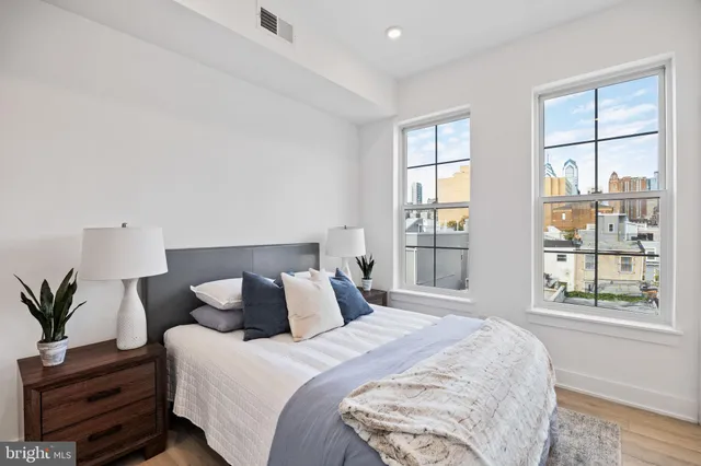 a bedroom with bed and wooden floor