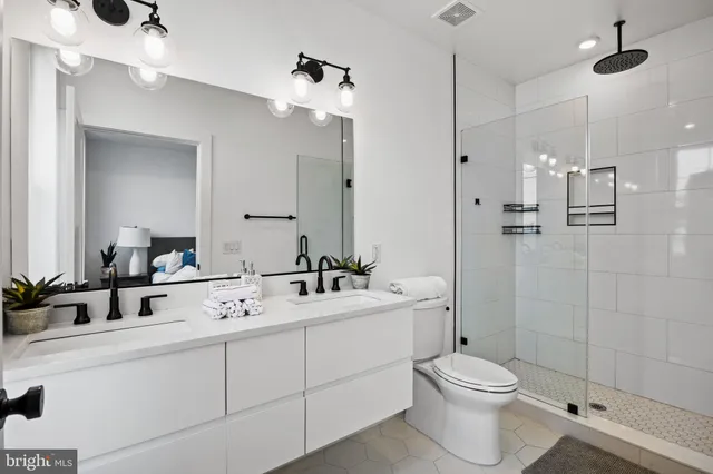 a bathroom with a double vanity sink toilet and shower