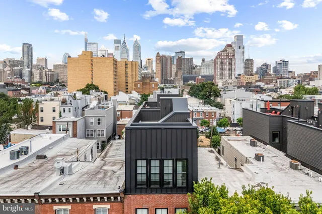 a tall building with a table and chairs potted plants