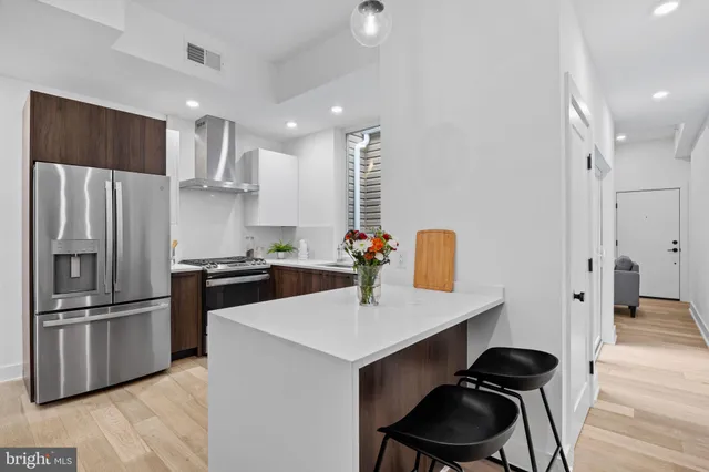 a kitchen with stainless steel appliances a refrigerator and a stove top oven