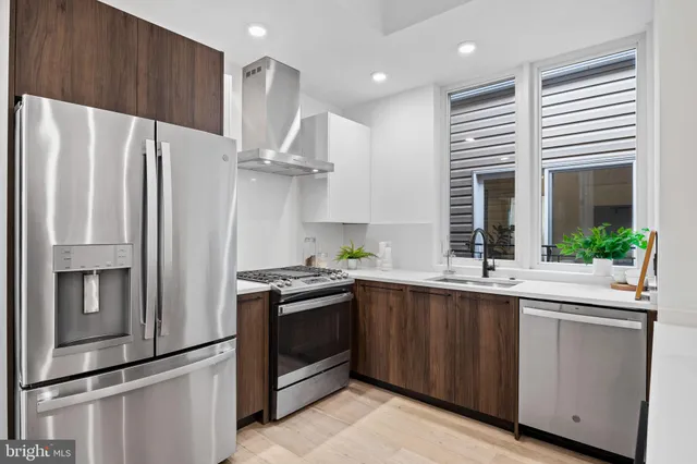 a kitchen with stainless steel appliances a refrigerator and a sink