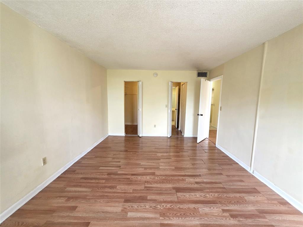 2800 Northwest 56th Avenue, Unit E304 Lauderhill, FL 33313 - Photo 8 of 15 a view of an empty room with wooden floor and closet