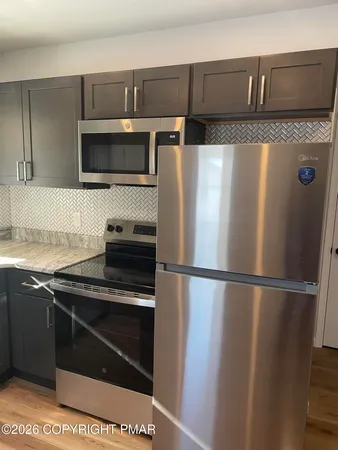 a kitchen with stainless steel appliances granite countertop a refrigerator and a sink