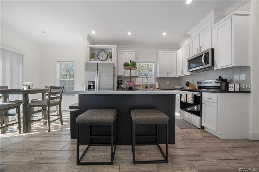 7962 West Riverbend Road Crystal River, FL 34428 - Photo 11 of 30 a kitchen with stainless steel appliances granite countertop a table and chairs in it