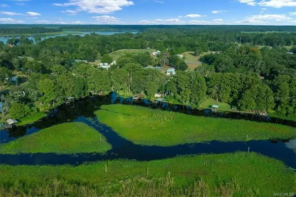 an aerial view of a house with a yard and lake view
