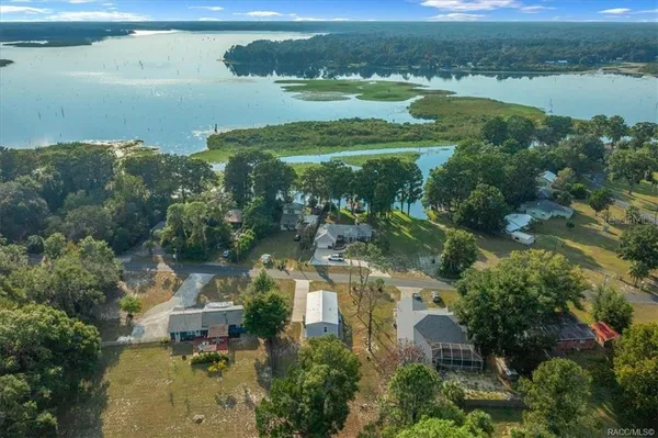 an aerial view of lake residential house with outdoor space and trees around