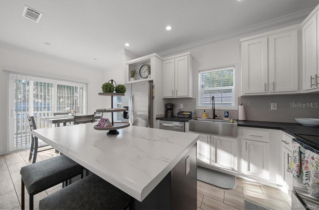 7962 West Riverbend Road Crystal River, FL 34428 - Photo 10 of 30 a large kitchen with sink a counter and chairs