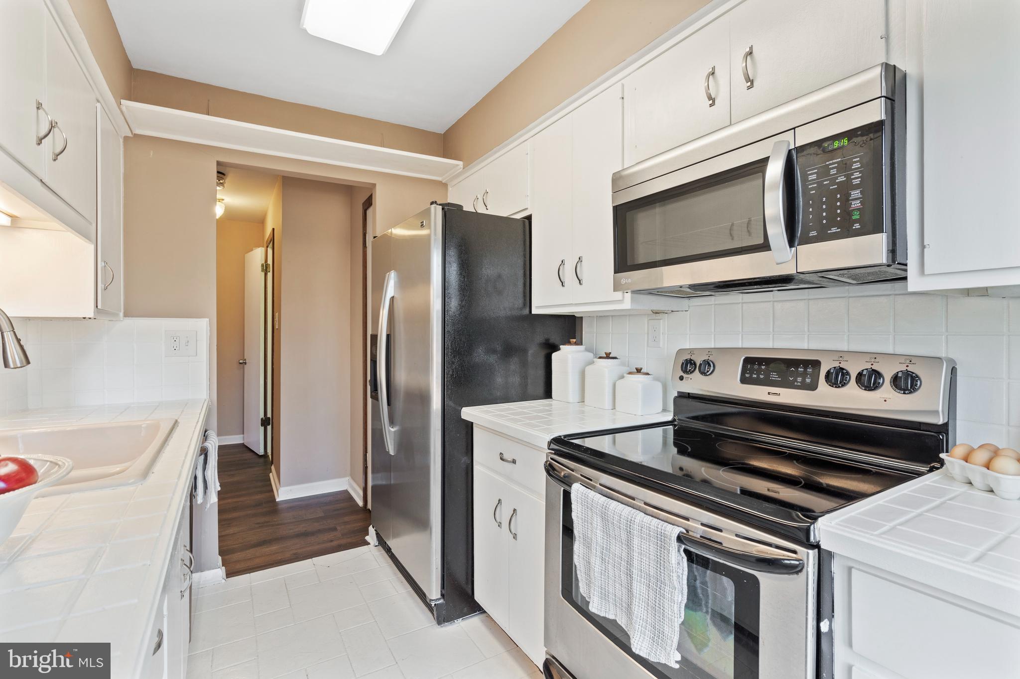 519 St Davids Road, Unit 3 Wayne, PA 19087 - Photo 14 of 31 a kitchen with stainless steel appliances a stove a microwave and a refrigerator