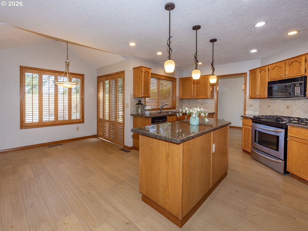 1811 Northwest 19th Street Gresham, OR 97030 - Photo 12 of 39 a kitchen with stainless steel appliances granite countertop a stove a sink a refrigerator and a oven