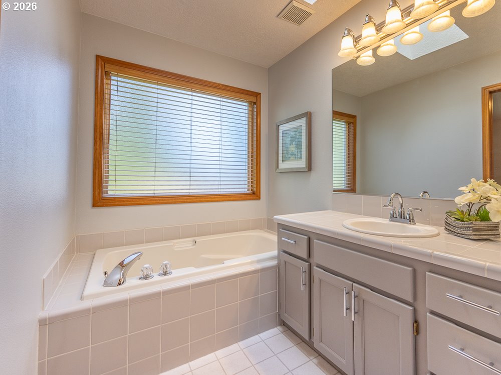 1811 Northwest 19th Street Gresham, OR 97030 - Photo 22 of 39 a bathroom with a tub sink and mirror