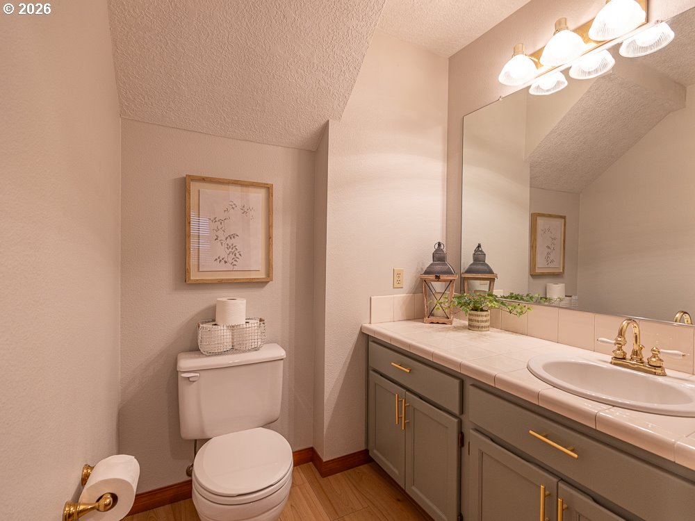 1811 Northwest 19th Street Gresham, OR 97030 - Photo 30 of 39 a bathroom with a granite countertop toilet sink and mirror