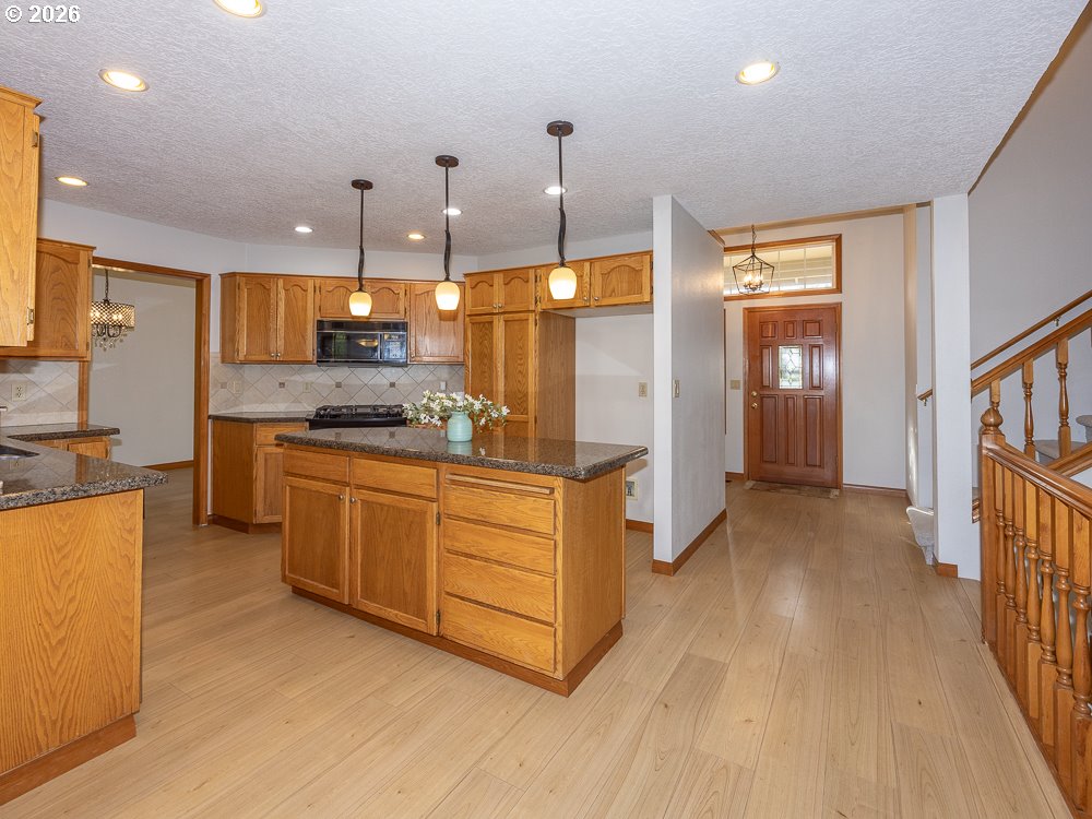1811 Northwest 19th Street Gresham, OR 97030 - Photo 10 of 39 a kitchen with stainless steel appliances kitchen island granite countertop a stove a sink a refrigerator and cabinets