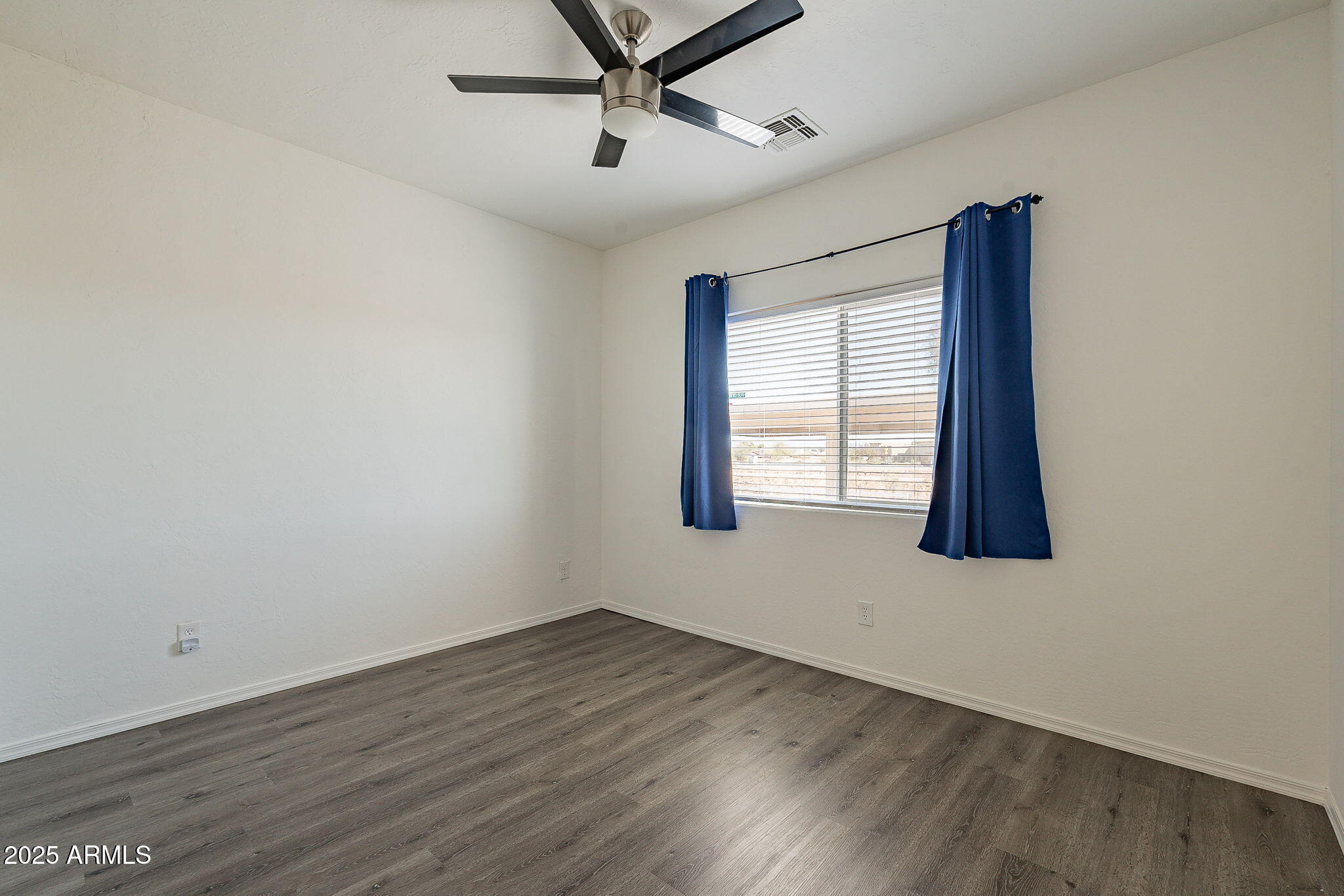 2300 East Magma Road, Unit 160 San Tan Valley, AZ 85143 - Photo 22 of 44 an empty room with wooden floor windows and ceiling fan