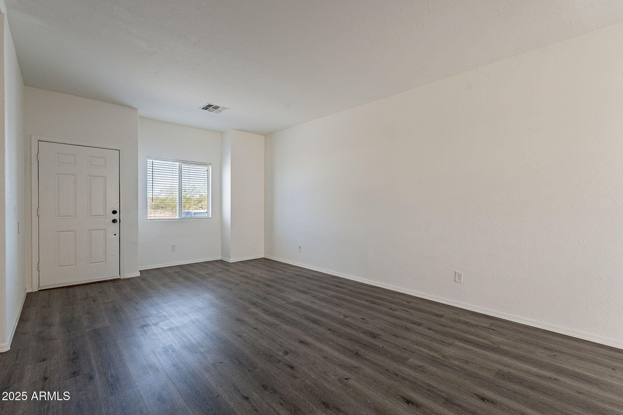 2300 East Magma Road, Unit 160 San Tan Valley, AZ 85143 - Photo 6 of 44 a view of an empty room with wooden floor and window