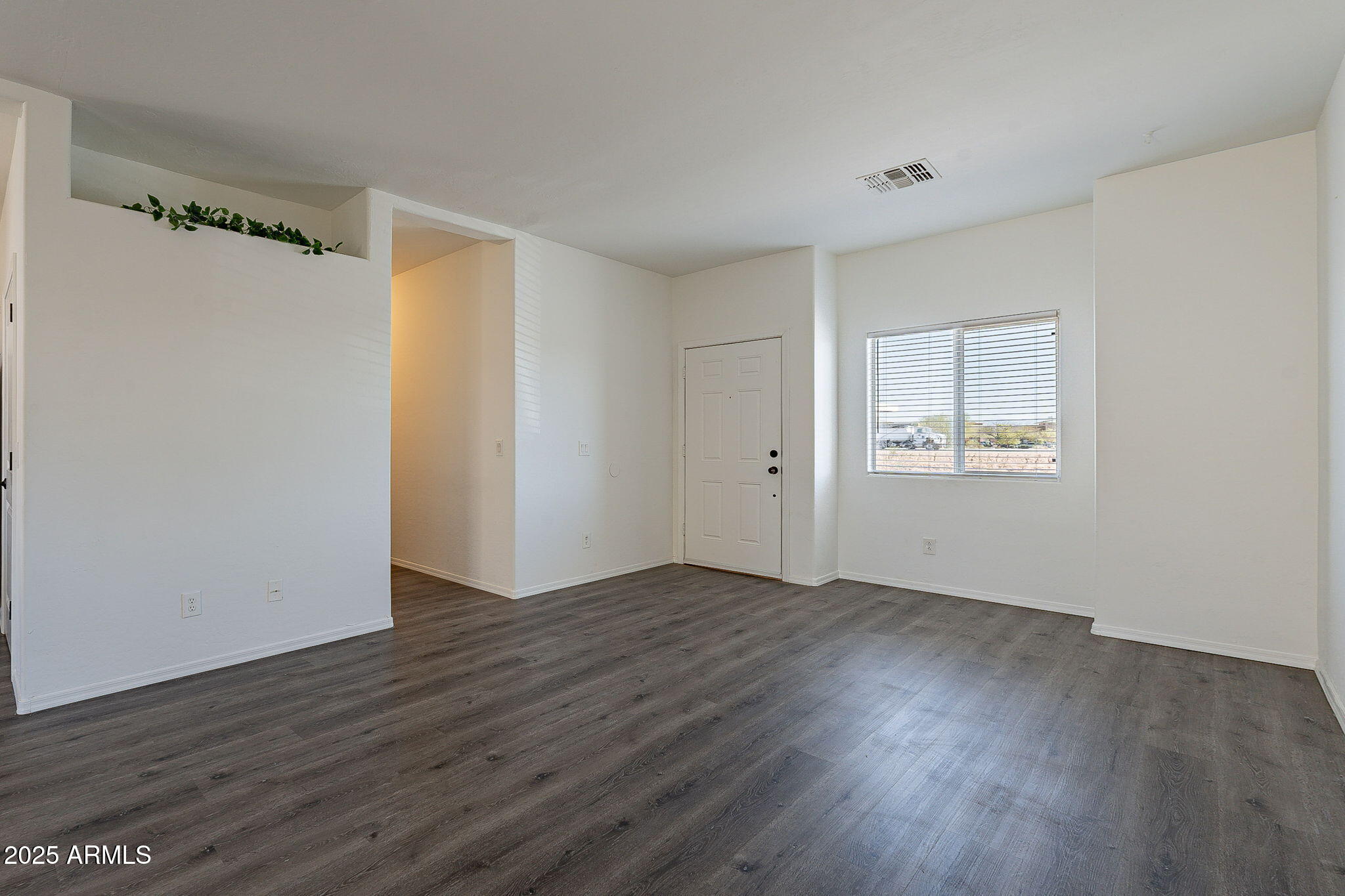 2300 East Magma Road, Unit 160 San Tan Valley, AZ 85143 - Photo 7 of 44 a view of an empty room with wooden floor and a window