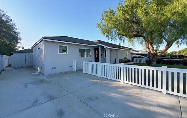 a view of a house with a small yard and a large tree