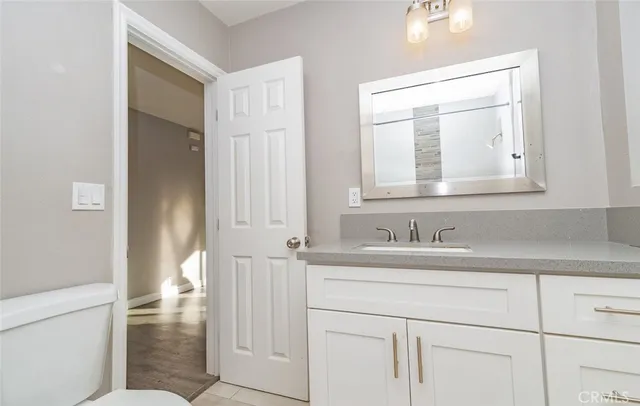 a bathroom with a sink a toilet and a mirror