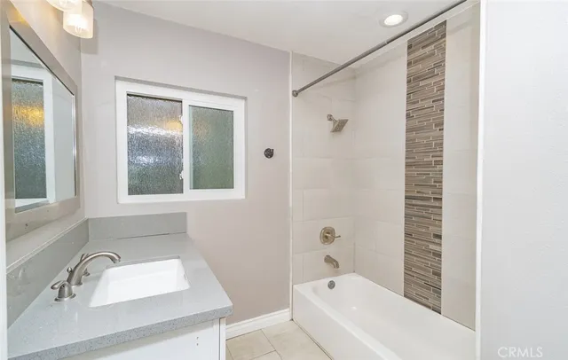 a bathroom with a tub shower and sink