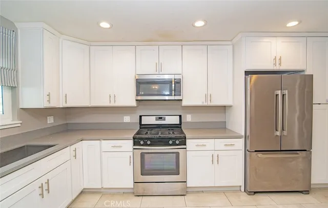 a kitchen with a refrigerator stove and white cabinets
