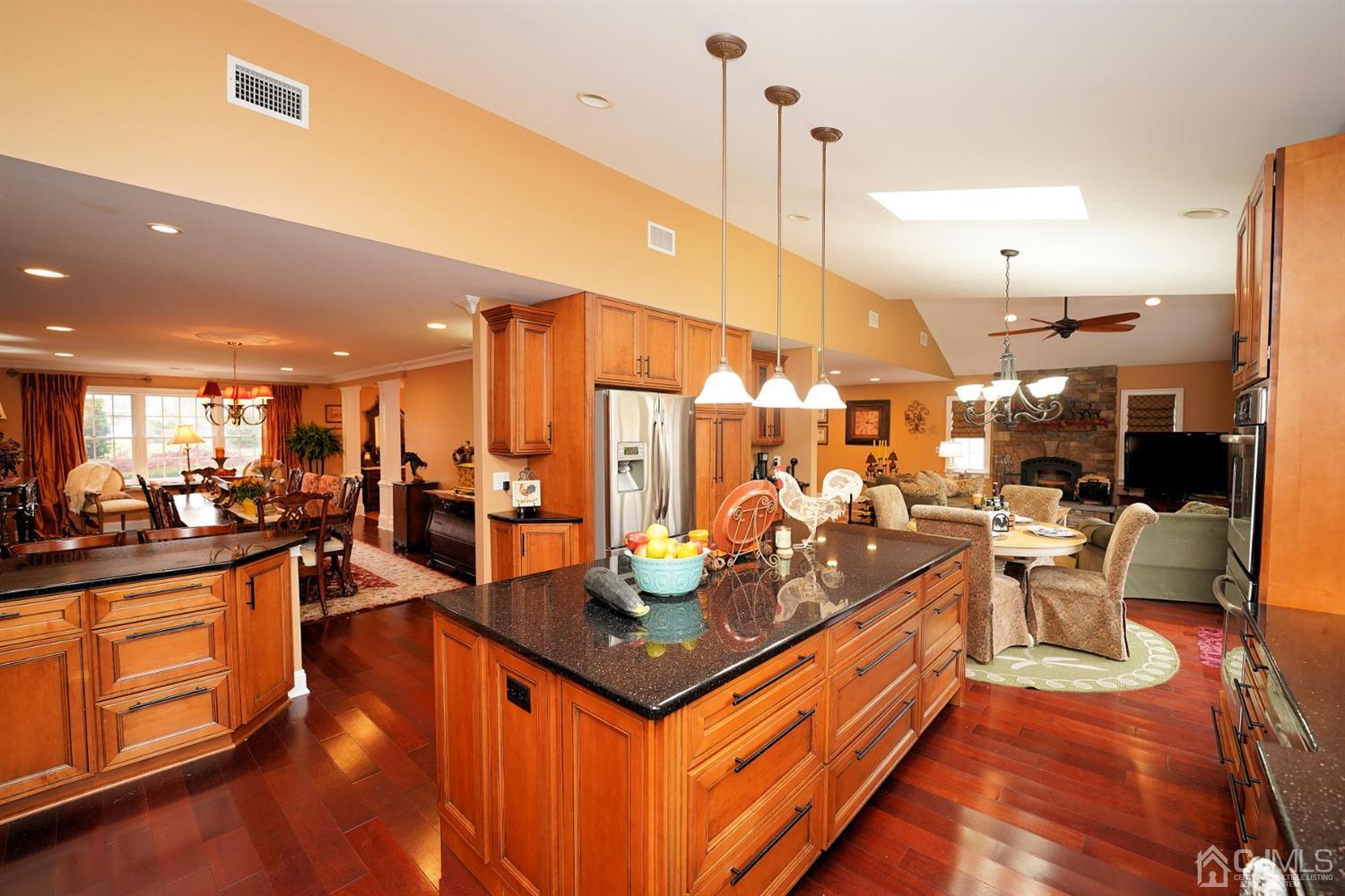 56 Kingsley Road Kendall Park, NJ 08824 - Photo 18 of 62 a view of a kitchen with kitchen island stainless steel appliances a stove a sink a center island and living room view