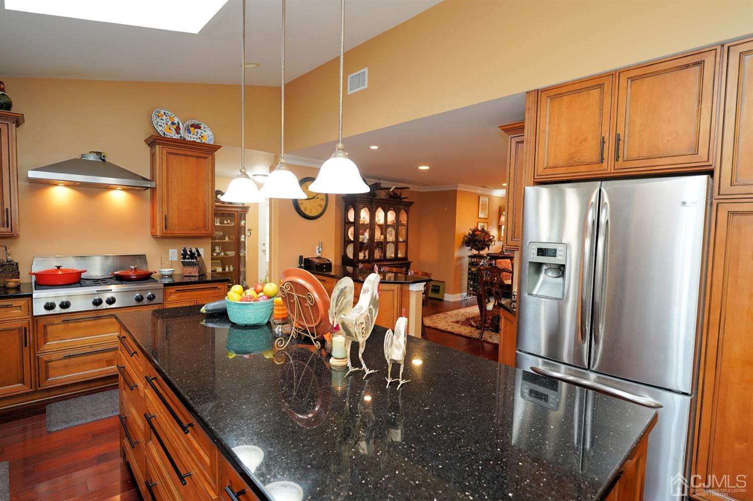 56 Kingsley Road Kendall Park, NJ 08824 - Photo 21 of 62 a kitchen with stainless steel appliances granite countertop a refrigerator a dining table and chairs