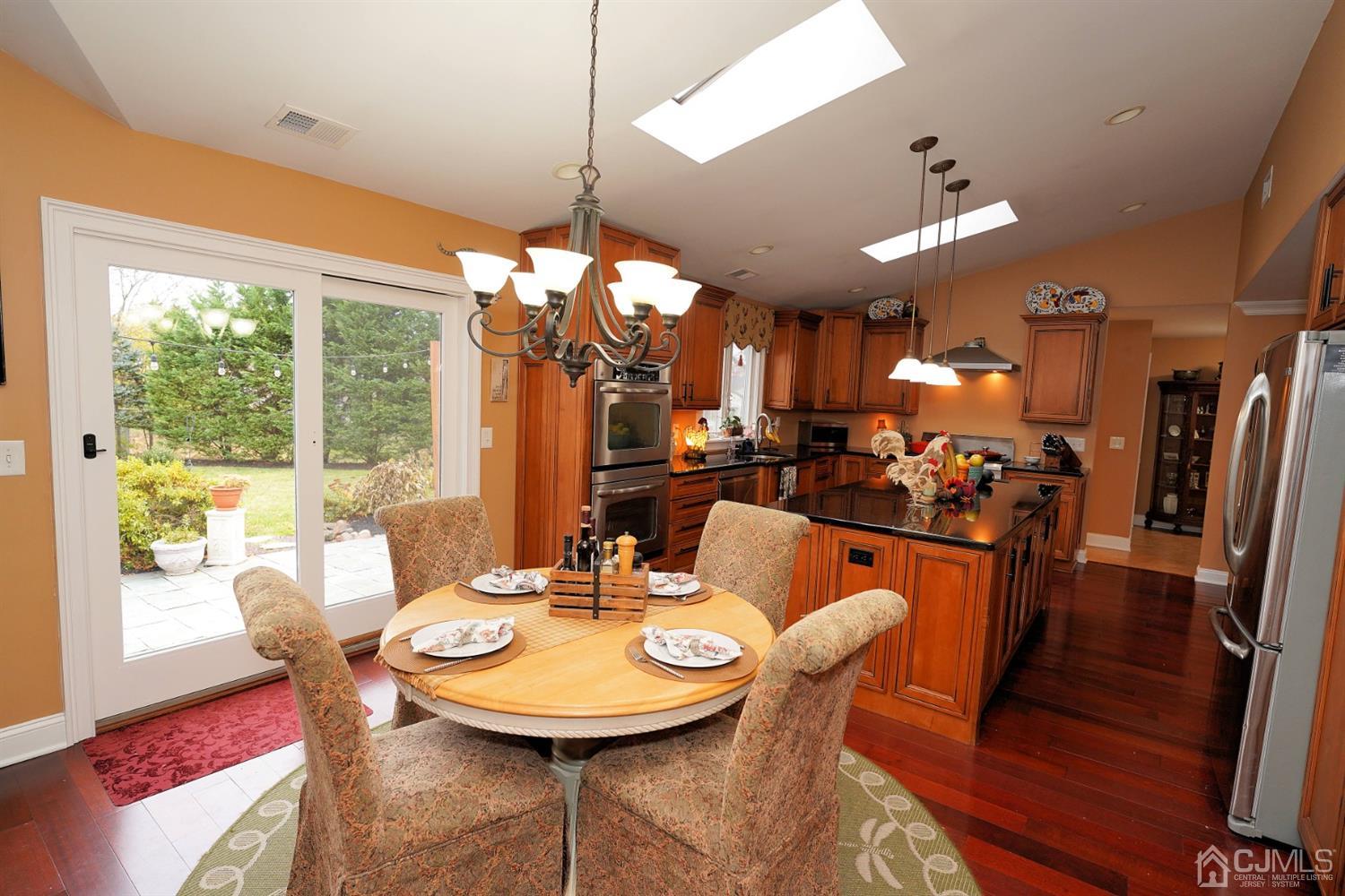 56 Kingsley Road Kendall Park, NJ 08824 - Photo 23 of 62 a view of a dining room with furniture wooden floor and chandelier