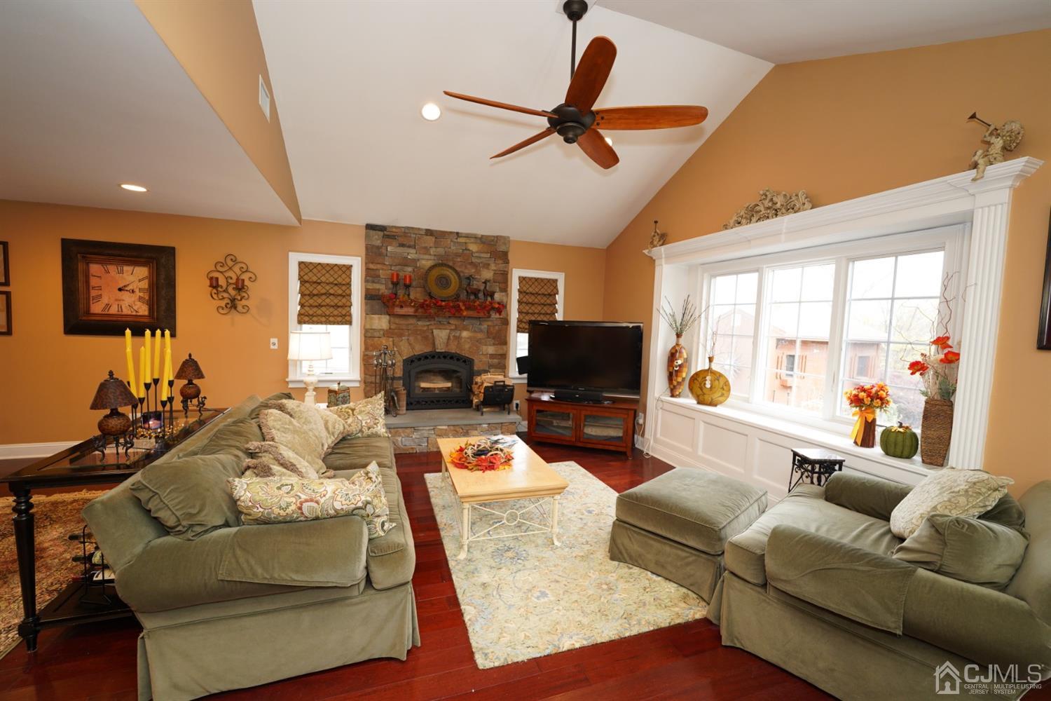 56 Kingsley Road Kendall Park, NJ 08824 - Photo 26 of 62 a living room with furniture a ceiling fan and a flat screen tv