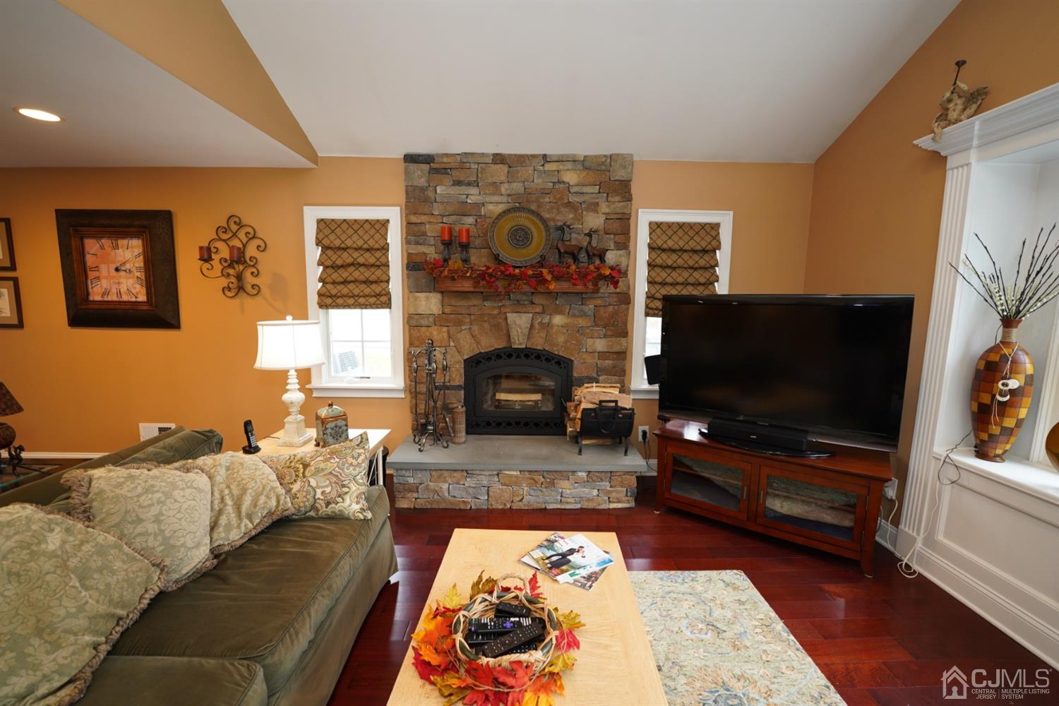 56 Kingsley Road Kendall Park, NJ 08824 - Photo 27 of 62 a living room with furniture flat screen tv and a fireplace