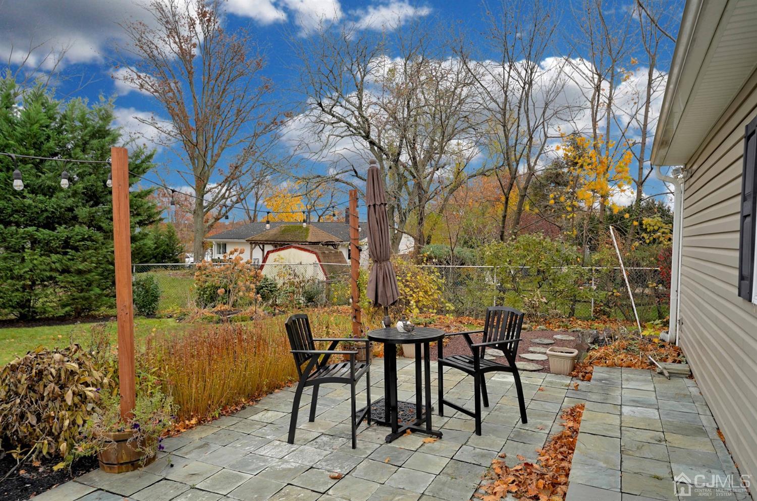 56 Kingsley Road Kendall Park, NJ 08824 - Photo 58 of 62 a view of a patio with table and chairs and potted plants