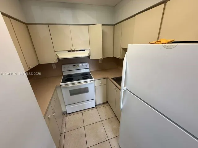 a kitchen with a stove and a white refrigerator
